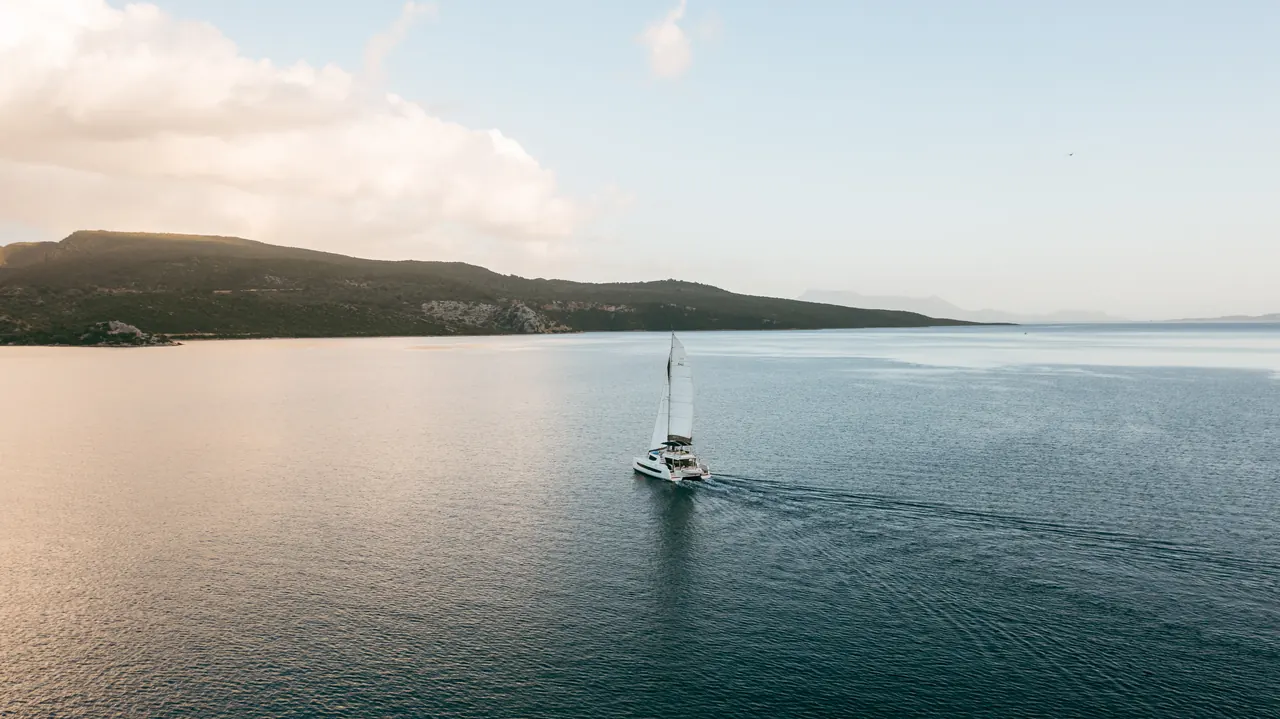 The Olea catamaran at anchor in a turquoise bay