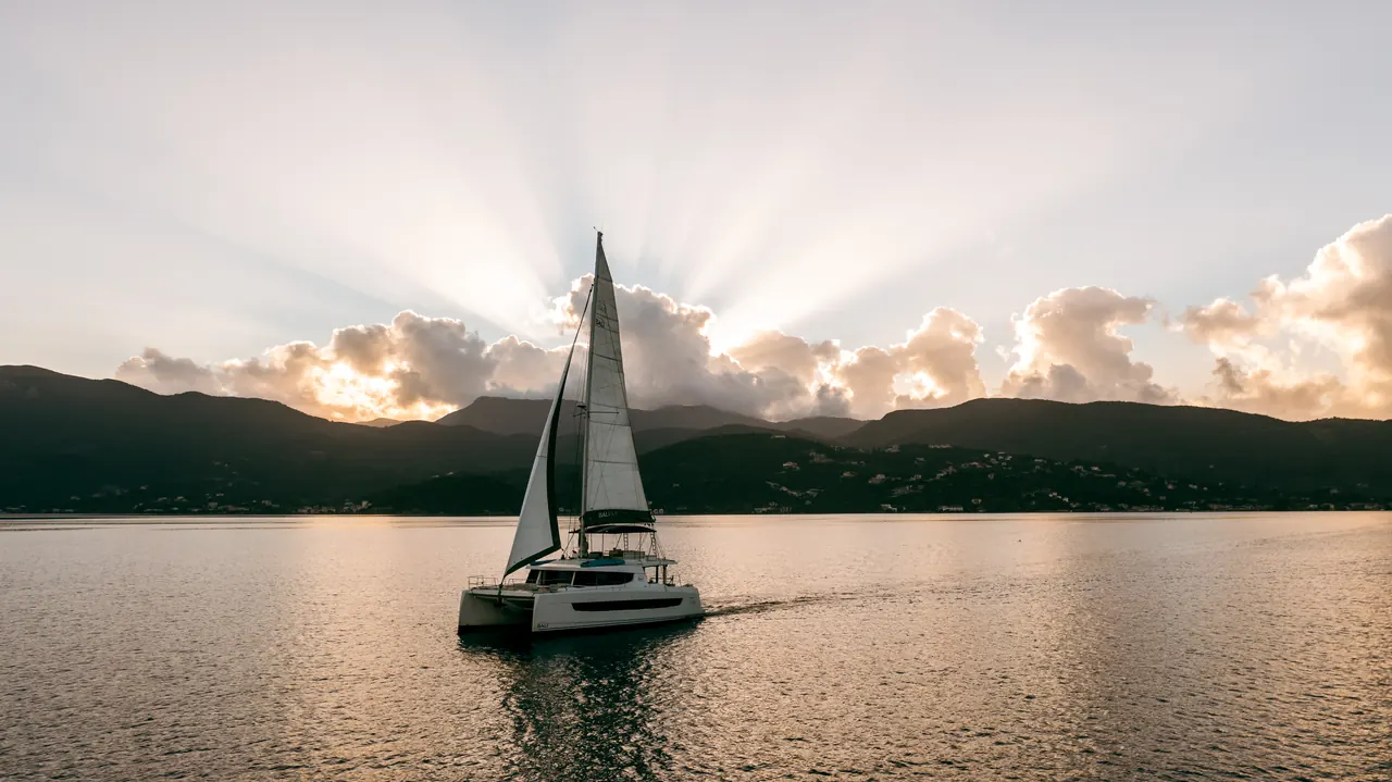 Catamaran sailing at sunset